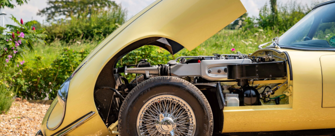 Cross-Ply vs Radial Tyres: What’s Best for Your Classic Car? Yellow jaguar e -type close up shot with the bonnet open showing cross-ply tyre and wire spoke rims