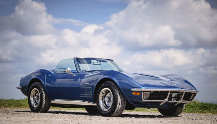 iconic classic car designs - Corvetter Stingray convertible in blue against a stunning sky backdrop